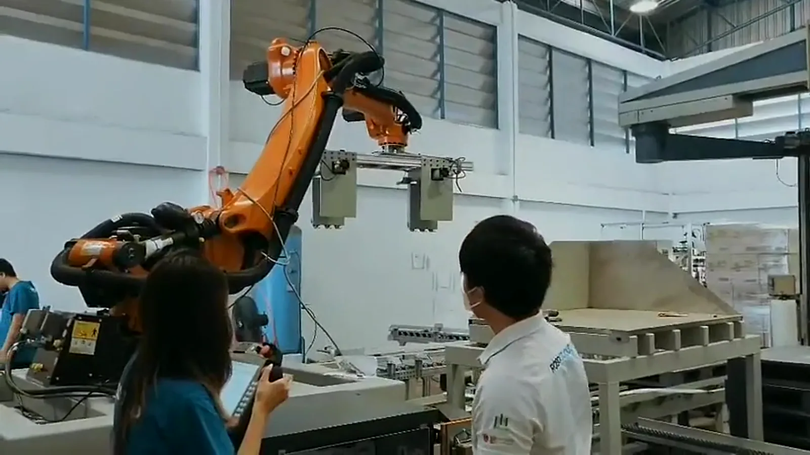 RoboCloud engineers discussing an industrial robot cell